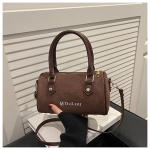 Detail view of mini Boston bag in brown matte suede with white embroidery and gold hardware