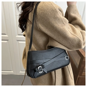 Close-up of black leather shoulder bag featuring silver buckle and crisscross strap detail