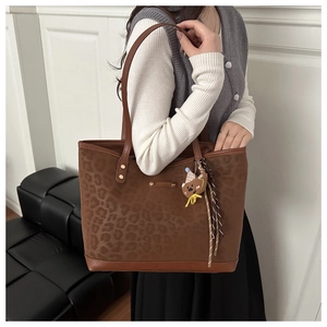 Détail du sac cabas léopard avec logo Fashion en métal et breloque petit ours