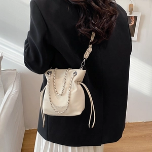 Modern off-white leather bucket bag with silver chain and adjustable shoulder strap