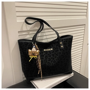 Détail du sac cabas léopard avec logo métallique FASHION et breloque ours en peluche