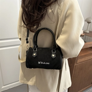 Vintage black frosted Boston shoulder bag with white embroidery held by a model