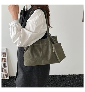 Detail of olive green suede tote bag with white contrast stitching and mini side pouch