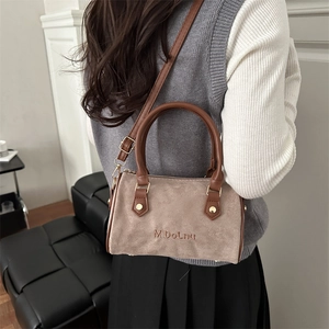 Retro taupe suede Boston bag with leather handles and gold-tone hardware shown on shoulder