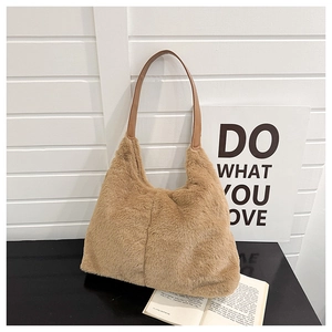 Gros plan du sac cabas en peluche marron montrant la texture douce et l'anse en cuir