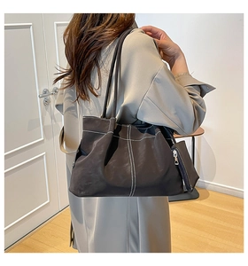 Detailed view of deep brown suede tote bag with contrast stitching and matching pouch