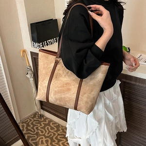 Elegante borsa tote grande in camoscio beige con manici in pelle marrone e anelli metallici