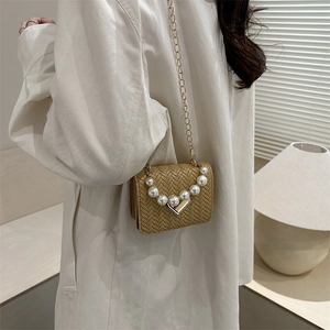 Khaki woven leather crossbody bag with pearl chain and gold hardware on model