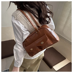 Détail du sac bandoulière rétro en cuir ciré marron avec doubles poches à verrou rotatif