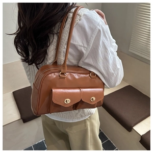 Détail d'un sac à bandoulière marron vintage en similicuir avec deux poches à boucles dorées