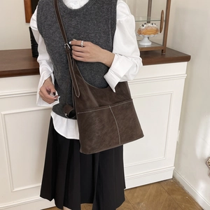 Brown vintage hobo tote bag with white contrast stitching shown on female model