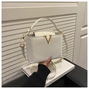Détails de luxe du sac en cuir blanc avec boucle en V dorée et finitions raffinées