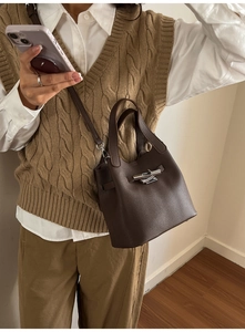 Détail du sac seau en cuir grainé marron foncé avec fermoir rotatif argenté et anse