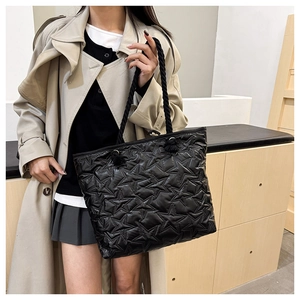 Detail of black quilted tote bag with star stitching and thick rope shoulder straps