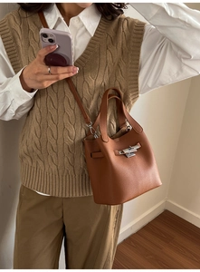 Detailed view of a brown pebbled leather bucket bag with silver twist-lock closure