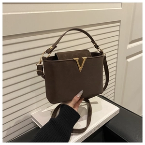 Vue détaillée du sac seau en cuir marron foncé avec boucle métallique en V dorée
