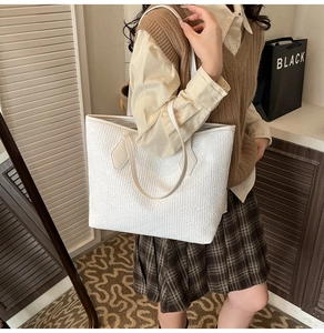 Détail d'un grand cabas blanc avec texture matelassée et doubles anses sur un mannequin