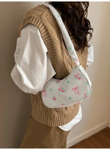 Close-up of white bubble fabric hobo bag with pink rose patterns and bow details