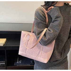Detailed view of the pink leather tote bag with dual straps worn in a lifestyle setting
