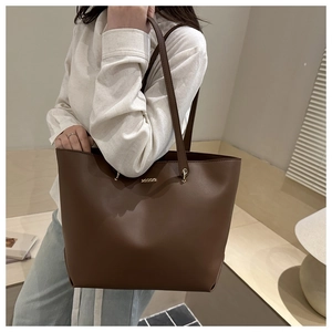 Dark brown large leather tote bag worn by a model to show size and stylish fit