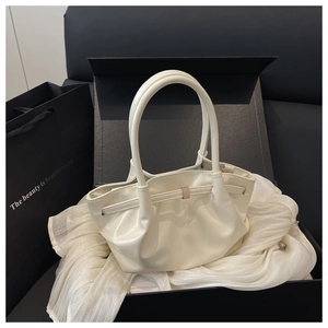 Détail du sac seau en cuir blanc dans un coffret cadeau avec tissu en soie et boucle en métal