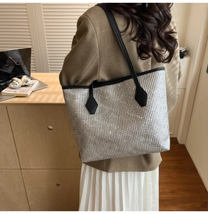 Détail du sac cabas argenté texturé avec fines lanières en cuir noir à l'épaule