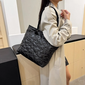 Fashionable black quilted tote bag with star patterns and woven rope shoulder straps