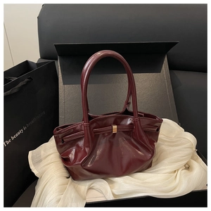 Détails de ce sac seau bordeaux avec sa boucle noeud métallique et sa poignée chic