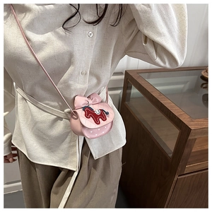 Detail van roze gewatteerde mini-crossbodytas met een strik en borduursel van een paard