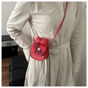 Petit sac bandoulière rouge avec nœud géant et broderie cheval porté par un mannequin