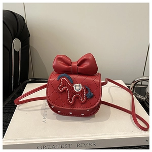 Macro-opname van rode mini crossbodytas voor kinderen met leren strik en paardenborduurwerk
