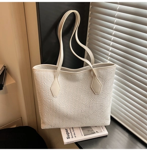 Détail du sac cabas blanc montrant le grain fin et le renfort de poignée en losange