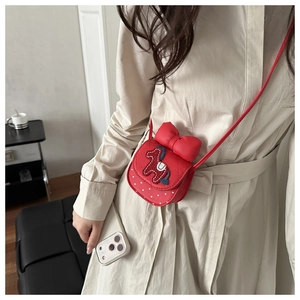 Détail d'un sac bandoulière matelassé rouge avec nœud et broderie poney sur un mannequin