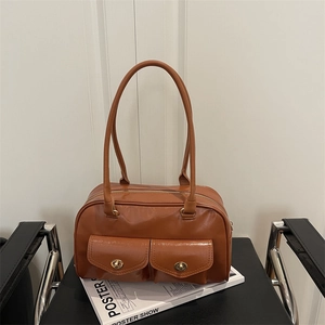 Retro brown leather pillow bag with dual front pockets and elegant gold turn-lock buckles