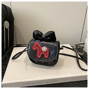 Detail van zwarte gewatteerde mini tas met lederen strik en rode paardenborduurwerk decoratie