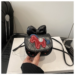 Detail van zwarte gewatteerde crossbodytas met rood paardenborduurwerk en een strik