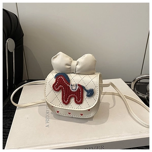Detail van witte gewatteerde crossbodytas met geborduurde pony en een grote strik