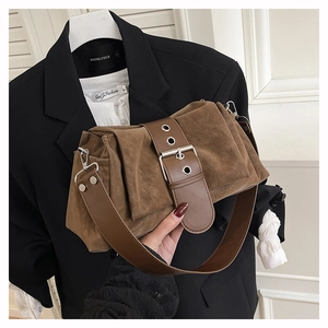 Nahaufnahme der braunen Wildledertasche mit breitem Gurt, Metallösen und Schnalle