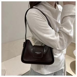 Détail du sac baguette marron foncé avec imprimé FASHION & BAGS porté par un mannequin