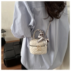 Mini quilted cream crossbody bag with silk scarf handle and gold chain strap detail