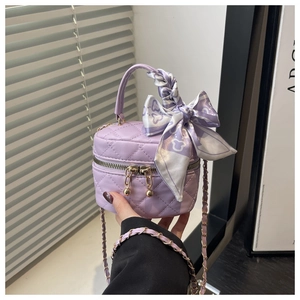 Detailed view of lavender quilted mini handbag with decorative silk scarf handle