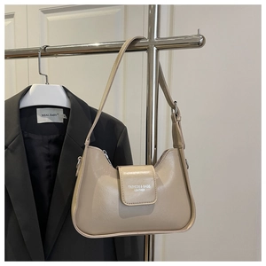 Détail du sac baguette beige en similicuir avec boucles argentées et fermeture magnétique