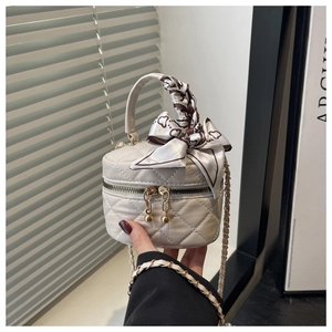 Detail of white quilted mini handbag with silk scarf handle and double zipper pulls