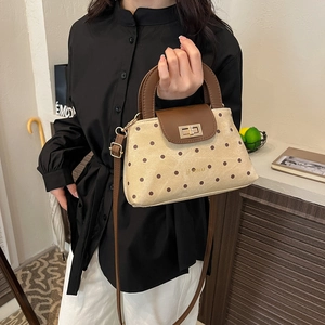 Retro beige polka dot handbag with brown leather trim and golden twist-lock closure
