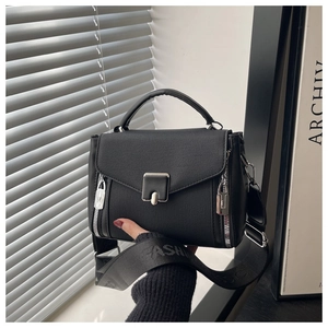 Close-up of black crossbody bag with silver buckle and fashion printed wide strap