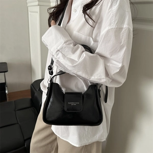 Sac sous le bras minimaliste en cuir noir brillant avec logo blanc et design incurvé