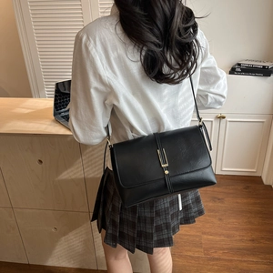 Vintage French black leather crossbody bag for women with a sleek metal bar and thin strap