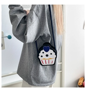 Detail of creative cupcake-shaped crossbody bag with polka dots and blue heart accents
