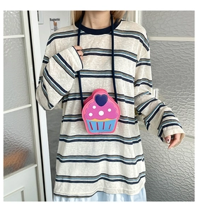 Detailed view of cupcake-shaped crossbody bag with pink cream layer and blue heart charm