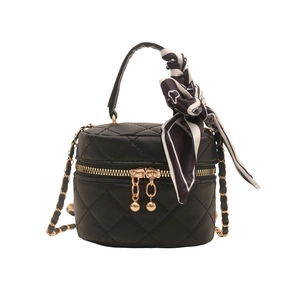 Quilted black cylinder handbag with gold hardware and decorative silk scarf handle